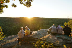 Sunrise at Old Furnace State Park as people watch.